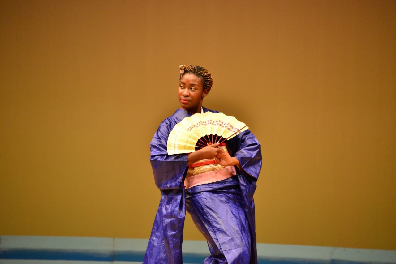 Dr Dédé in a blue kimono pose with fan