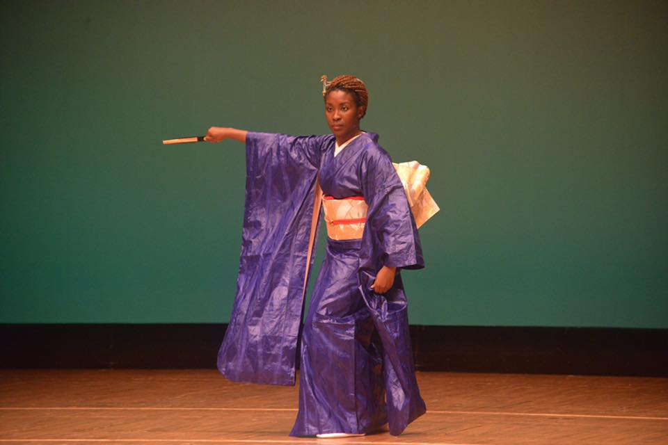 Dr Dédé in blue kimono with outstretched fan